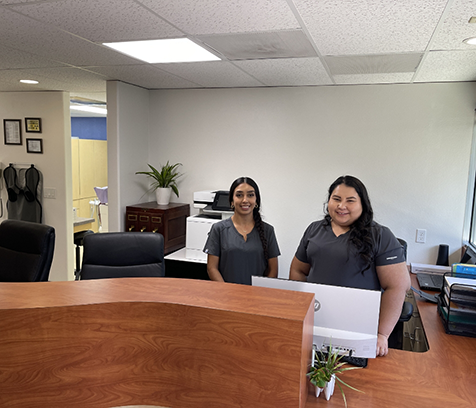 Two team members in black shirts at front desk of Campbell dental office