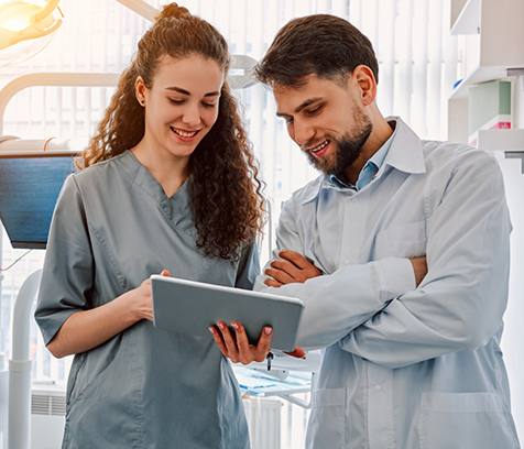 Two dentists looking at a tablet