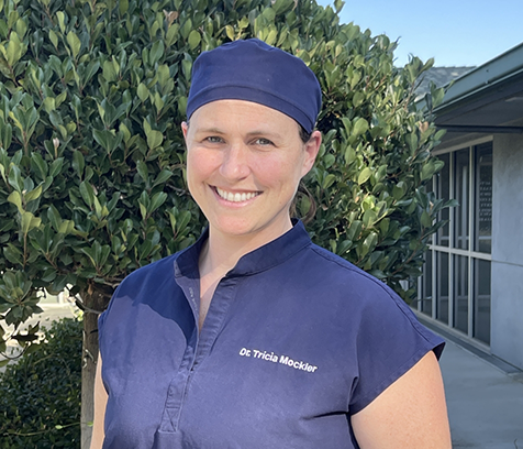 Dr. Tricia Mockler outside with dentist uniform and hat