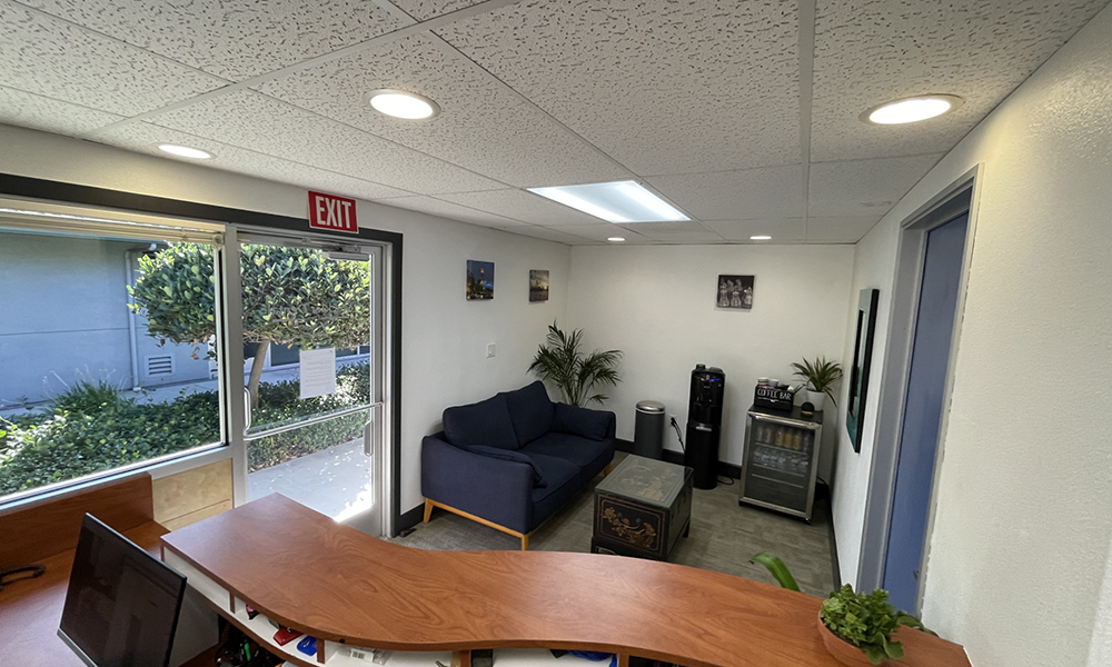 Waiting room with table, couch, and fridge