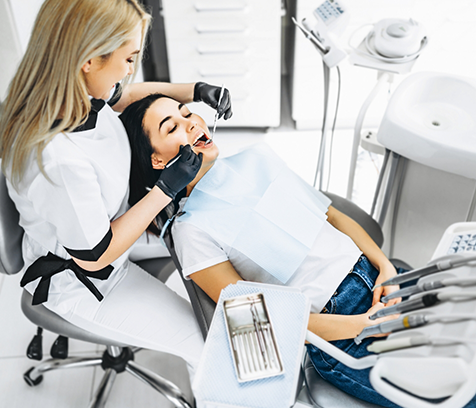 Female patient receiving dental checkup from female dentist